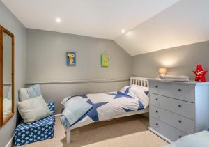 a childs bedroom with a bed and a chair at Fern Lea in Brancaster