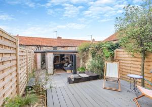 a backyard with a wooden deck with a fence at Fern Lea in Brancaster
