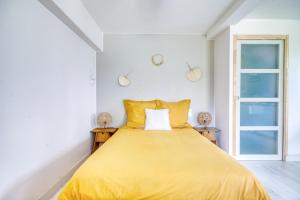 ein Schlafzimmer mit einem gelben Bett und einem Fenster in der Unterkunft gîte ARGOAT Ty Kaouenn in Plumergat