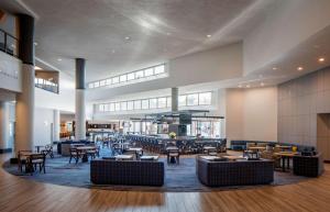 a lobby with tables and chairs in a building at Hyatt Regency Santa Clara in Santa Clara