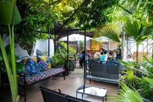 un patio con divani e piante in un ristorante di Victoria Falls Backpackers Zambia a Livingstone