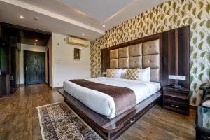 een slaapkamer met een groot bed in een kamer bij Kamal Residency By Revanta Hospitality Mcleodganj in Dharamshala