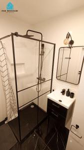 La salle de bains est pourvue d'une douche et d'un lavabo. dans l'établissement Pod Brzozami Apartamenty Gąski, à Gąski