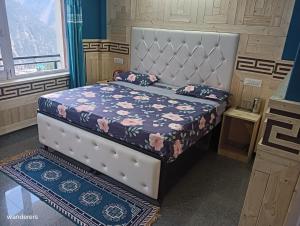 1 dormitorio con 1 cama con colcha de flores en Wanderers Homestay -All mountain facing rooms en Kalpa