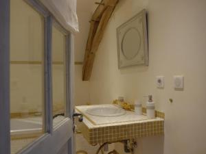 een badkamer met een wastafel, een bad en een spiegel bij Le Prieuré de Loups in Saint-Michel-en-Brenne
