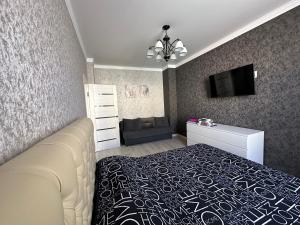 um quarto com uma cama e uma televisão de ecrã plano em 1 комн.квартира em Balkhash