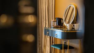 ein Badezimmer mit einem Waschtisch mit einem Spiegel und einem Stuhl in der Unterkunft Howfield Hotel in Merthyr Tydfil