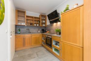 a kitchen with wooden cabinets and a sink at Birkenstraße 6 Haus II Whg1 in Zingst