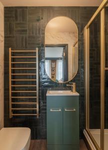 ein Bad mit einem Waschbecken und einem Spiegel in der Unterkunft Howfield Hotel in Merthyr Tydfil