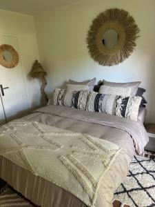 1 dormitorio con cama con almohadas y espejo en Le Bailli Saint Tropez, en Saint-Tropez