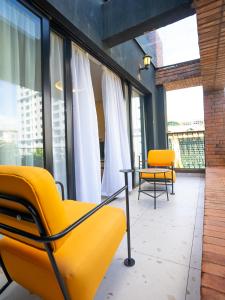 a room with yellow chairs and a table and windows at Zarafa Suites in Nairobi
