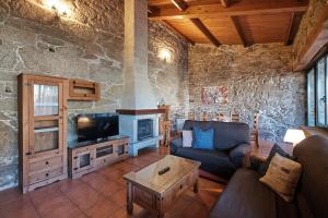 a living room with a couch and a fireplace at Entre Pedra e Mar by Serendipia Turismo in Goyanes