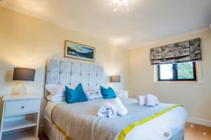a bedroom with a large bed with blue pillows at Guest Homes - Longscroft Manor in Bradford on Avon