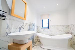 Guest Homes - Longscroft Manor في برادفورد أون آفون: حمام أبيض مع حوض ومرآة