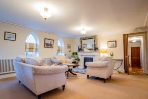 a living room with two chairs and a fireplace at Guest Homes - Longscroft Manor in Bradford on Avon