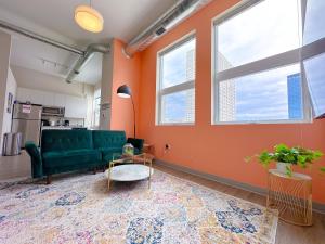 ein Wohnzimmer mit einem grünen Sofa und 2 Fenstern in der Unterkunft McCormick Place 2br-2ba with Optional Parking,Patio,Gym for 6 guests in Chicago