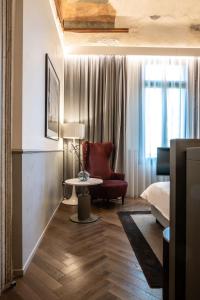 a room with a bed and a chair and a table at Radisson Collection Hotel, Palazzo Nani Venice in Venice