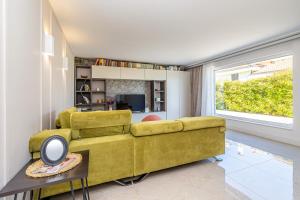 een woonkamer met een gele bank en een raam bij Apartman SIORA in Njivice