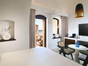 a hotel room with a bed and a table and a television at Movenpick Resort El Quseir in Quseir