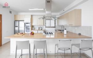 una cucina con armadi bianchi e un'isola con sgabelli da bar di Luxury apartments' in Netanya a Netanya