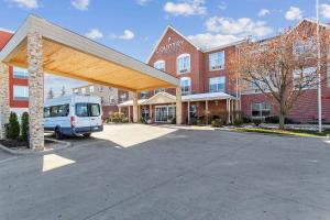 a van parked in a parking lot in front of a building at Country Inn & Suites by Radisson, Chicago O'Hare South, IL in Bensenville
