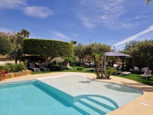 - une piscine dans une cour avec des chaises et un parasol dans l'établissement Villa Lekythos, à Agrigente