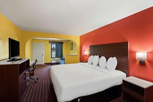 a hotel room with a large bed and a flat screen tv at SureStay by Best Western Gulfport in Gulfport