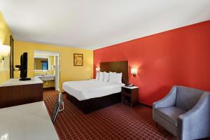 une chambre d'hôtel avec un lit et une chaise dans l'établissement SureStay by Best Western Gulfport, à Gulfport