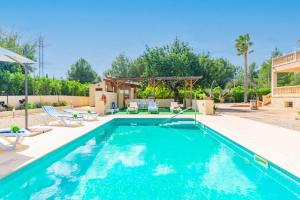 a swimming pool with blue water in a yard at Es Garroveret in Marratxí 