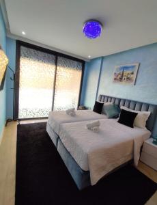 a bedroom with a large bed and a large window at Appartement de luxe sur agadir bay in Agadir