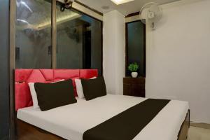a bedroom with a white bed with a red headboard at OYO Kashish Residency in New Delhi