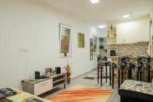 ein Wohnzimmer mit weißen Wänden und eine Küche in der Unterkunft Studio Apartments Dilberovic in Mostar
