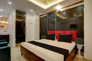 a bedroom with a large bed with a red headboard at OYO Kashish Residency in New Delhi