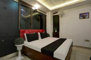 a bedroom with a bed with black and red pillows at OYO Kashish Residency in New Delhi
