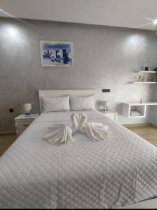 a bedroom with a white bed with a white comforter at Appartement de luxe sur agadir bay in Agadir