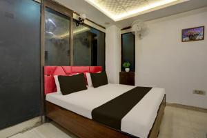 a bedroom with a bed with a red head board at OYO Kashish Residency in New Delhi