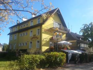 a yellow building with an umbrella in front of it at Hotel Korona in Ciechanów