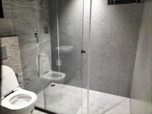 y baño con ducha de cristal y aseo. en Coorg Riverness Resort, en Kushālnagar