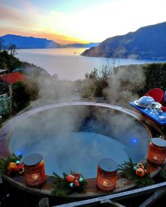 una vasca idromassaggio con vista su uno specchio d'acqua di Private Romantic Wellness Lake View Retreat- Whirlpool Hammam Spa e Piscina panoramica a Maccagno Superiore