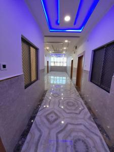 Ayodhya的住宿－Goroomgo Hotel The Nirmala Palace Ayodhya-Near Ram Mandir，走廊设有蓝色天花板和瓷砖地板