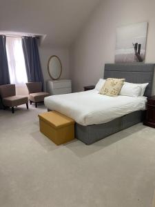 een slaapkamer met een groot bed en een stoel bij Merchiston Residence in Edinburgh