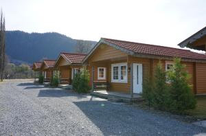 a row of wooden cottages on a gravel road at Orkla Camping in Orkanger