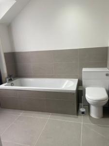a bathroom with a bath tub and a toilet at Merchiston Residence in Edinburgh