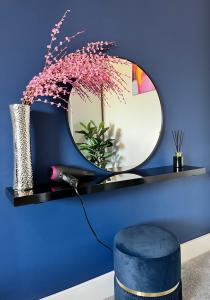 een spiegel op een blauwe muur met een blauwe muur bij Luxury Norwich City Centre Apartment - Free Parking in Norwich