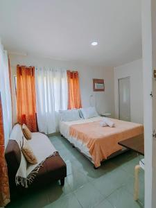 a bedroom with a bed and a chair in it at HOST HOMES-SANDY LANE in Tacloban
