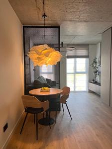 a dining room with a table and chairs and a chandelier at "M&D ApartmentsLviv", Loft complex Great Britain in Lviv