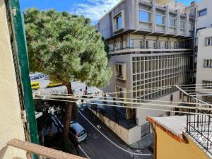 een appartement met een boom en een auto in een straat bij La casa di Piermaria in Varazze
