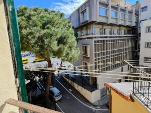 an apartment with a tree and a car on a street at La casa di Piermaria in Varazze