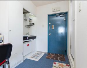 a blue door in a room with a kitchen at Ikebukuro 706 in Tokyo