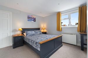 a bedroom with a bed and two lamps and a window at Kemendine Harbour View in Tenby